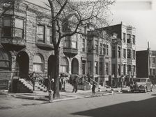 Old brown stonehouses now occupied by Negroes in Chicago, Illinois, April 1941. Creators: Farm Security Administration, Russell Lee