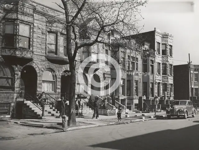 Old brown stonehouses now occupied by Negroes in Chicago, Illinois, April 1941. Creators: Farm Security Administration, Russell Lee.