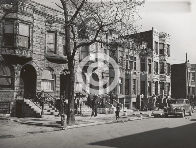Old brown stonehouses now occupied by Negroes in Chicago, Illinois, April 1941. Creators: Farm Security Administration, Russell Lee.