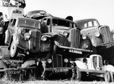Old cars piled up in a scrapyard, Britain