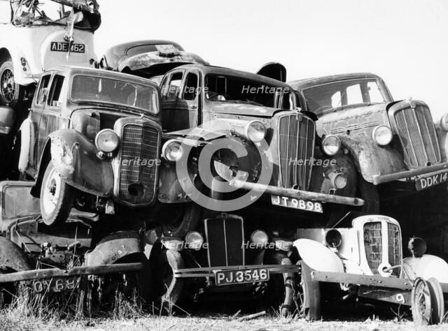 Old cars piled up in a scrapyard, Britain. Artist: Unknown