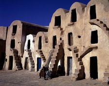 Old typical barns with people sitting on the stairs