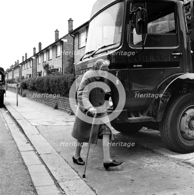 Old woman and truck on a London street, 1977. Creator: Henry Grant.