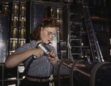 Operating a hand drill at the North American Aviation, Inc., a woman is in the control..., 1942. Creator: Alfred T Palmer