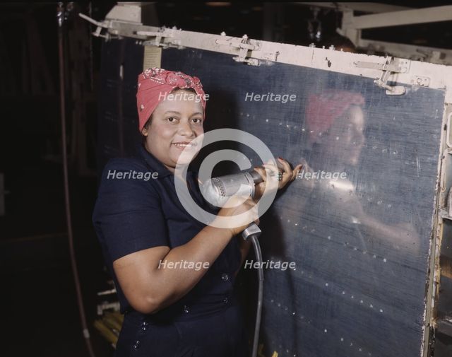 Operating a hand drill at Vultee-Nashville, woman is working on a "Vengeance" dive..., Tenn., 1943. Creator: Alfred T Palmer.