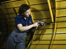 Operating a hand drill at Vultee-Nashville, woman is working on a "Vengeance" dive..., Tenn., 1943. Creator: Alfred T Palmer