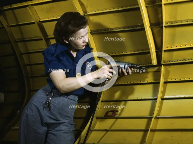 Operating a hand drill at Vultee-Nashville, woman is working on a "Vengeance" dive..., Tenn., 1943. Creator: Alfred T Palmer.