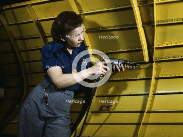 Operating a hand drill at Vultee-Nashville, woman is working on a "Vengeance" dive..., Tenn., 1943. Creator: Alfred T Palmer.