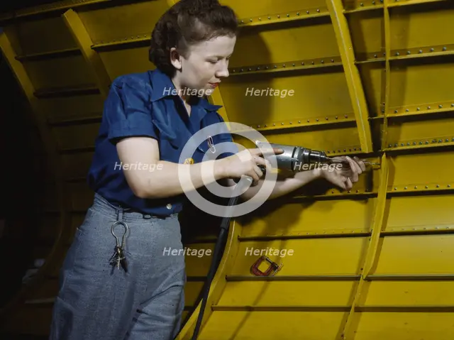 Operating a hand drill at Vultee-Nashville, woman is working on a "Vengeance" dive..., Tenn., 1943. Creator: Alfred T Palmer.