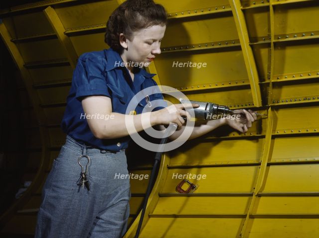 Operating a hand drill at Vultee-Nashville, woman is working on a "Vengeance" dive..., Tenn., 1943. Creator: Alfred T Palmer.