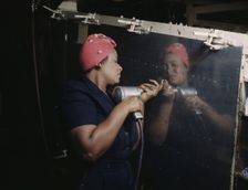 Operating a hand drill at Vultee-Nashville...working on a "Vengeance" dive bomber, Tennessee, 1943. Creator: Alfred T Palmer