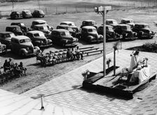 Outdoor church service with cars parked behind, USA, (1950s?)