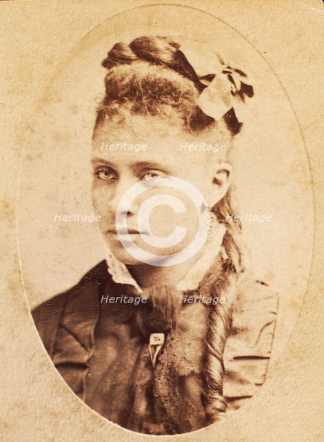 Oval portrait of unidentified young woman with long curl draped over chest. c1880-c1889. Creator: Unknown.