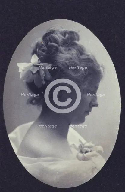 Oval portrait of woman with a flower in her hair and a corsage on her dress, c1900. Creator: Fannie L. Elton.