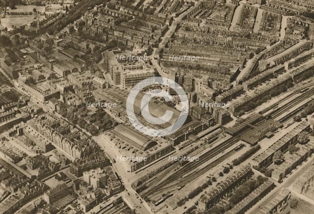 'Over Olympia and the Headquarters of the Post Office Savings Bank', c1935. Creator: Surrey Flying Services.