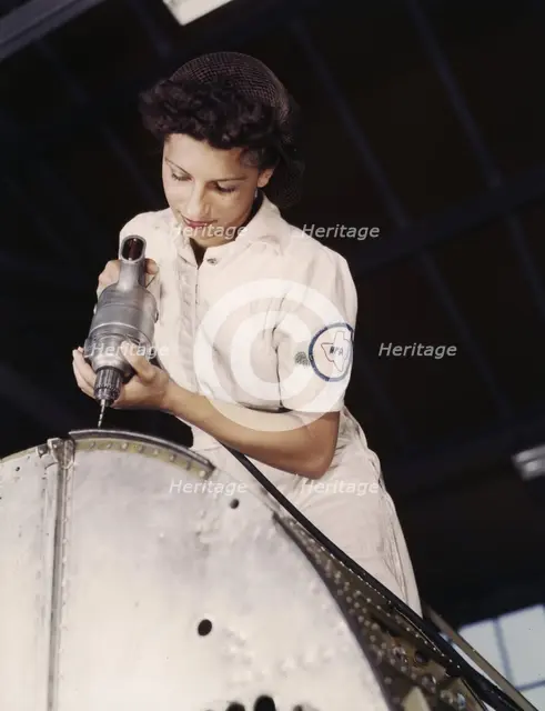 Oyida Peaks riveting as part of her NYA training...Naval Air Base, Corpus Christi, Texas, 1942. Creator: Howard Hollem.