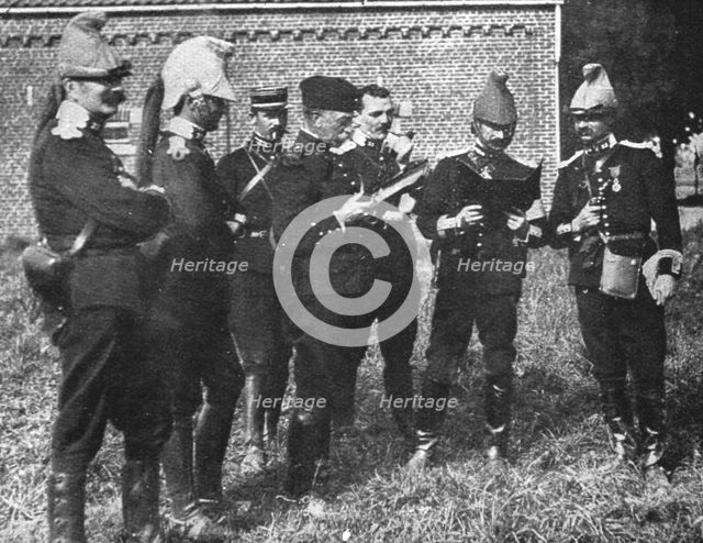 'L'aide Francaise a la Belgique; A l'ecart, l'etat-major de la brigade etudie la carte', 1914. Creator: Unknown.