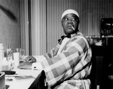 Louis Armstrong relaxing backstage, Finsbury Park Astoria, London, 1962. Creator: Brian Foskett
