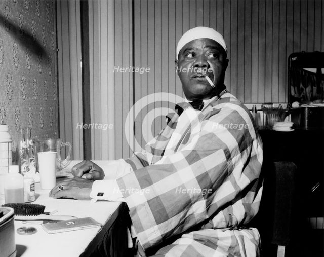 Louis Armstrong relaxing backstage, Finsbury Park Astoria, London, 1962. Creator: Brian Foskett.