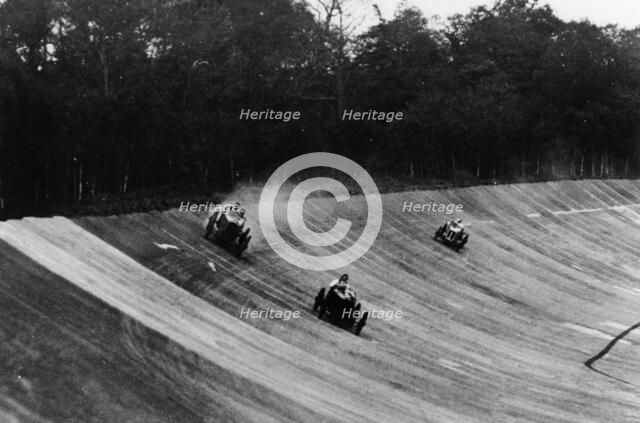 Louis Zborowski passing Humphrey Cook's Ballot by skidding above him, Brooklands. Artist: Unknown