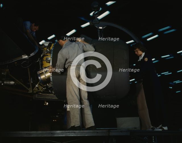 Lowering an engine in place in assembling a C-87...Consolidated Aircraft..., Fort Worth, Texas, 1942 Creator: Howard Hollem.