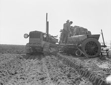 Loading bins of potato planter with fertilizer and seed..., Kern County, California, 1939. Creator: Dorothea Lange