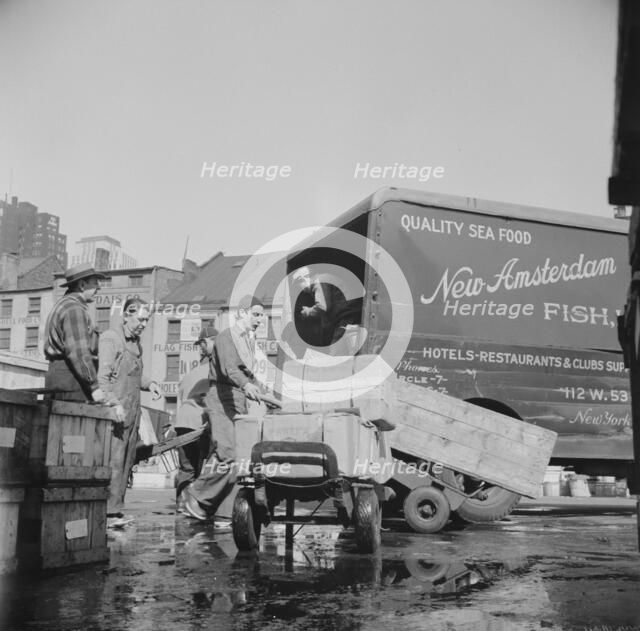 Loading boxes of fish to be shipped to hotels and restaurants at the Fulton fish..., New York, 1943. Creator: Gordon Parks.