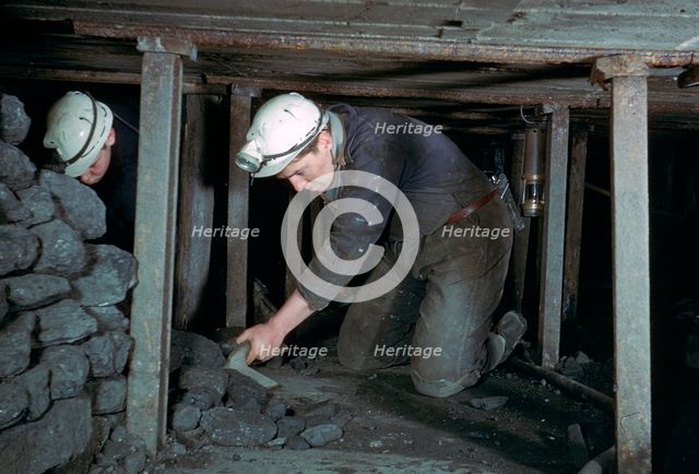 Loading coal onto a conveyer.