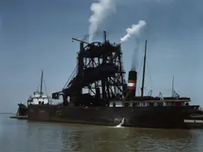 Loading coal into a freighter at one of the Pennsylvania Railroad docks, Sandusky, Ohio, 1943. Creator: Jack Delano