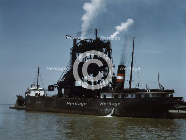 Loading coal into a freighter at one of the Pennsylvania Railroad docks, Sandusky, Ohio, 1943. Creator: Jack Delano.