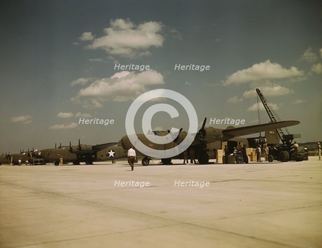 Loading new transport planes at the Consolidated Aircraft Corporation plant, Fort Worth, Texas, 1942 Creator: Howard Hollem.