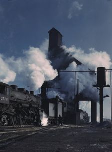 Locomotives over the ash pit at the roundhouse and coaling station...Chicago, Ill., 1942. Creator: Jack Delano