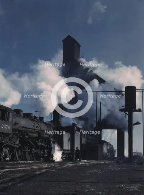 Locomotives over the ash pit at the roundhouse and coaling station...Chicago, Ill., 1942. Creator: Jack Delano.