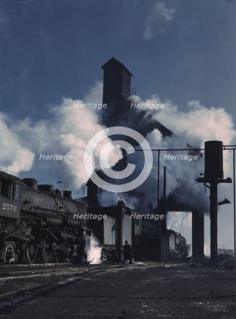 Locomotives over the ash pit at the roundhouse and coaling station...Chicago, Ill., 1942. Creator: Jack Delano.