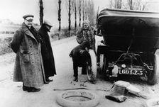 Lord Northcliffe's chauffeur changing a tyre, (c1908?)