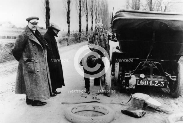 Lord Northcliffe's chauffeur changing a tyre, (c1908?). Artist: Unknown