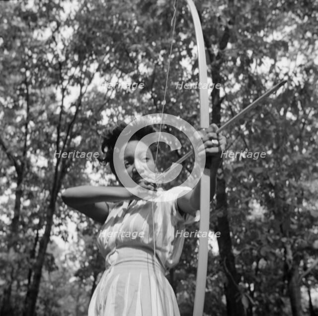 Loretta Gyles pulling a bow at Camp Fern Rock, Bear Mountain, New York, 1943 Creator: Gordon Parks.