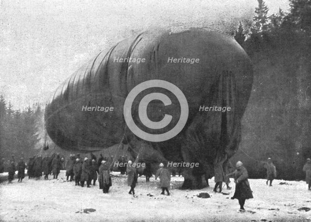 'La "Saucisse"; Avant l'ascension : "-- Sous son ventre ride de gros saurien, pend son…."', 1916. Creator: Unknown.