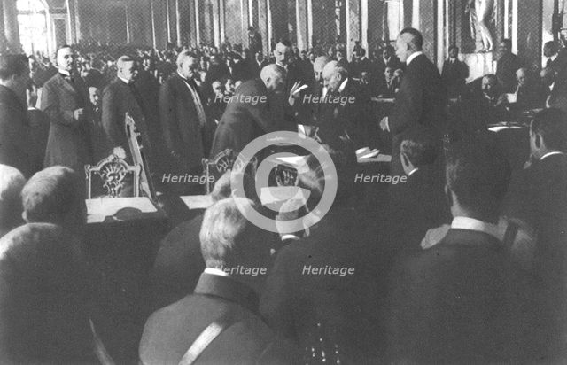 'La signature du traite de paix a Versailles; M Clemenceau signe debout: derriere..., 1919. Creator: Unknown.