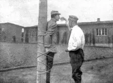 La peine du poteau; a Zwickau: un Francais, lie au poteau, recoit d'un prisonnier roumain..., 1917. Creator: Unknown
