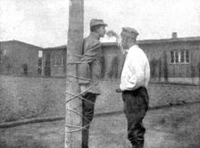 La peine du poteau; a Zwickau: un Francais, lie au poteau, recoit d'un prisonnier roumain..., 1917. Creator: Unknown