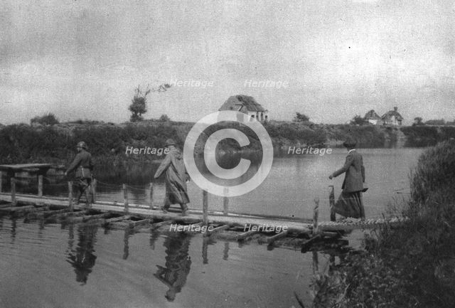 'La Reine des Belges sur les lignes de L'Yser; La reine traversant l'Yser sur une passerelle', 1916. Creator: Unknown.