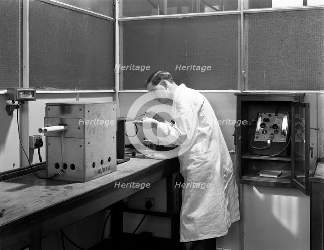Lab tachnician using a table top test furnace, Sheffield, South Yorkshire, 1962. Artist: Michael Walters