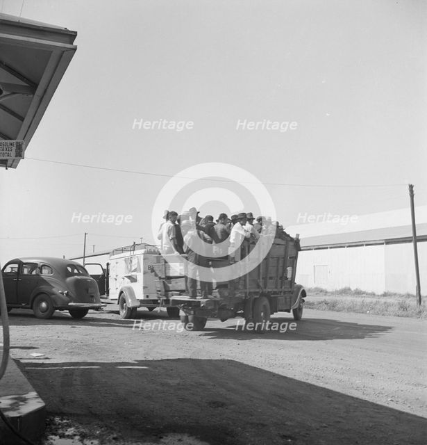 Labor contractor's truck with gang of pea pickers pulled up for gas, Westley, California, 1939. Creator: Dorothea Lange.