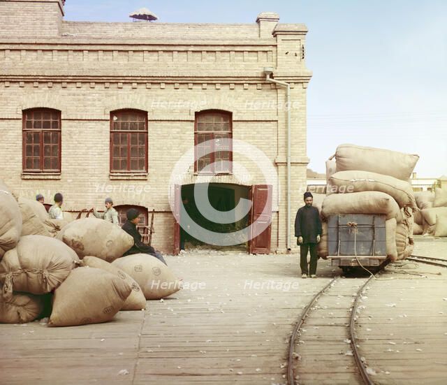 Labourers loading sacks onto railway at factory warehouse, between 1905 and 1915. Creator: Sergey Mikhaylovich Prokudin-Gorsky.