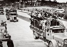 Labourers salute Hitler from packed trucks on a Nazi-built road, 1936. Creator: Unknown