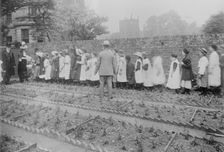 Lady Henry and T.P. O'Connor distribute cabbages, 1913. Creator: Bain News Service