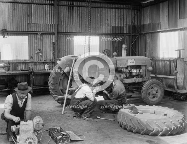 Laing workers carrying out maintenance work on the a Fordson Major Diesel Tractor, 22/07/1959. Creator: John Laing plc.