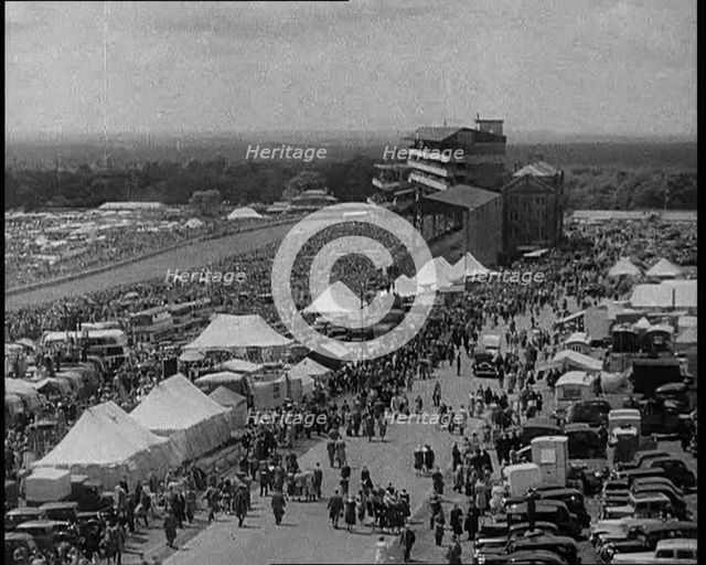 Large Crowd Sitting Outside with Cars and Tents, 1933. Creator: British Pathe Ltd.