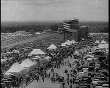 Large Crowd Sitting Outside with Cars and Tents, 1933. Creator: British Pathe Ltd